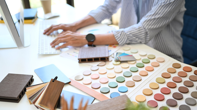 Designer putting together a room design with samples on the desk