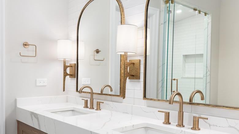Minimalist bathroom look with white tiles behind the mirrors