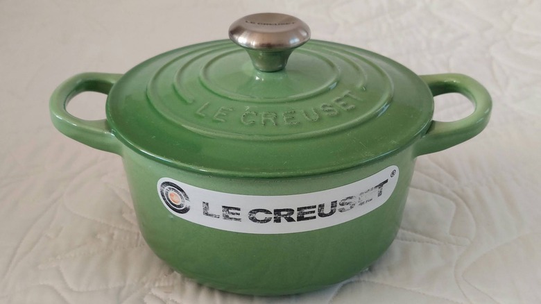 A small Le Creuset lidded pot in a medium green color known as Palm