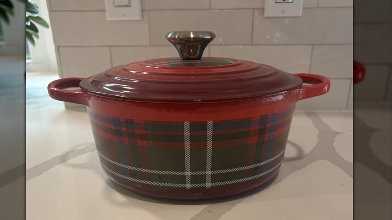A Le Creuset Dutch oven with a red plaid design