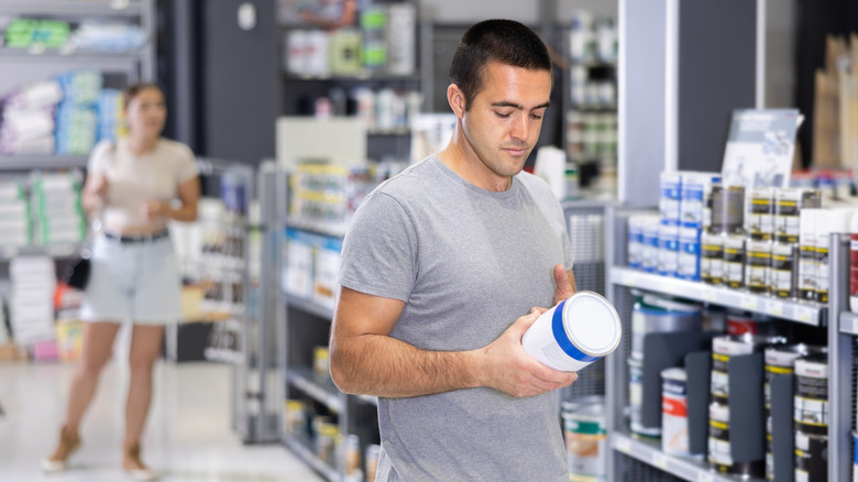 A man choosing paint an a DIY and hardware store