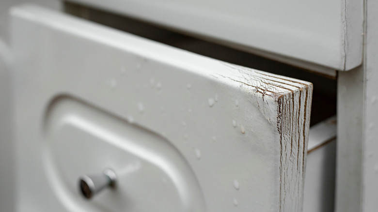 A wooden drawer peeling and cracking due to moisture exposure