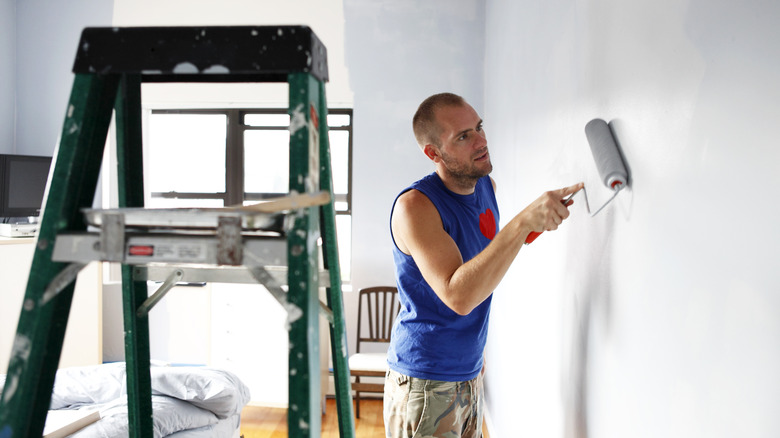 A man painting an interior wall