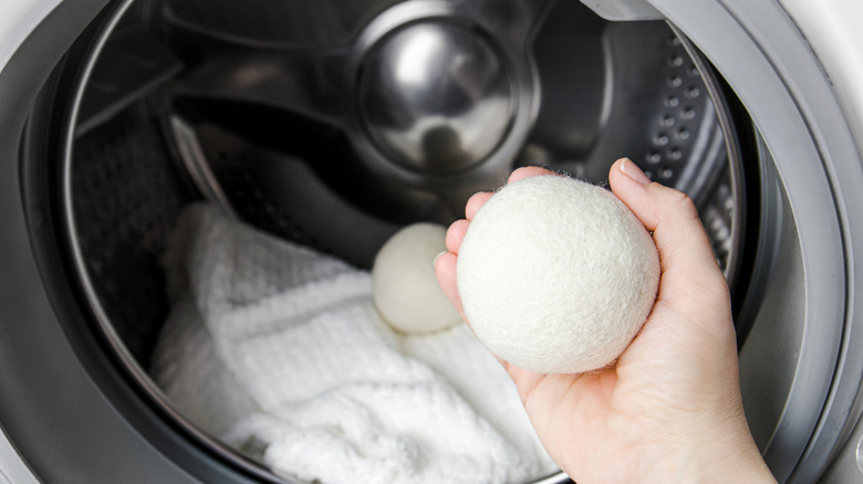 Hands placing dryer balls into a dryer