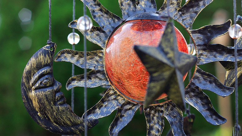 A celestial wind chime with a sun and moon.