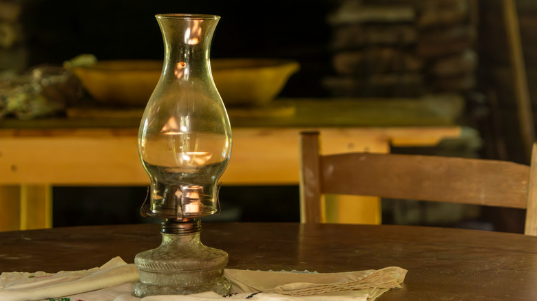 An antique paraffin lamp sitting on a table.