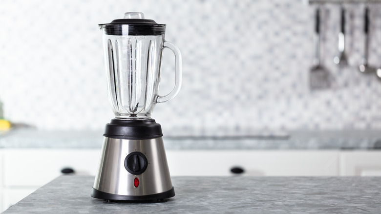 An empty kitchen blender on a granite kitchen worktop.