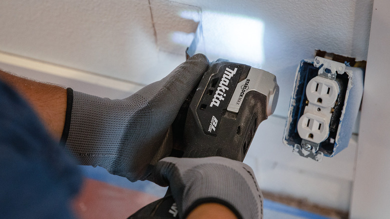 A person cutting out a section of drywall with Makita's 18V LXT Sub-Compact Lithium-Ion Brushless StarlockMax Cordless Multi-Tool