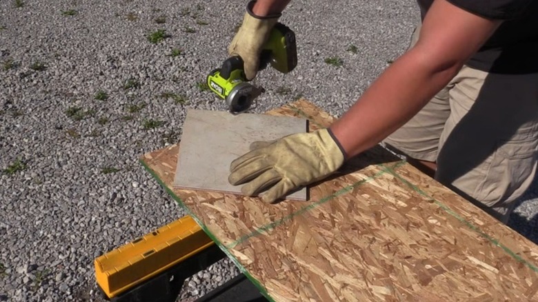 A person using Ryobi's 18V One+ Brushless Cordless Compact Cut-Off Tool on a tile