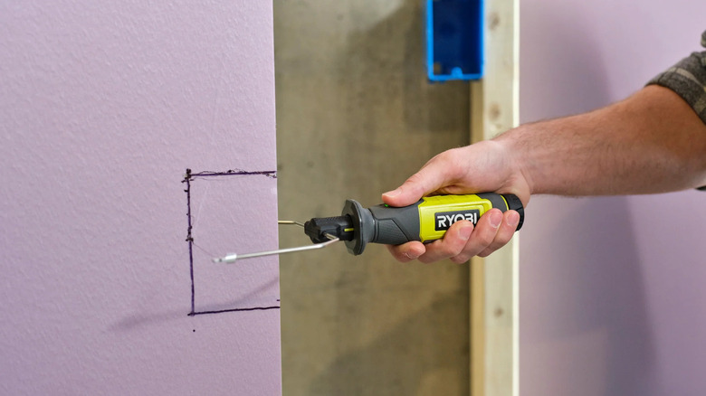 A person cutting a foam board with Ryobi's USB Lithium Hot Wire Foam Cutter Kit