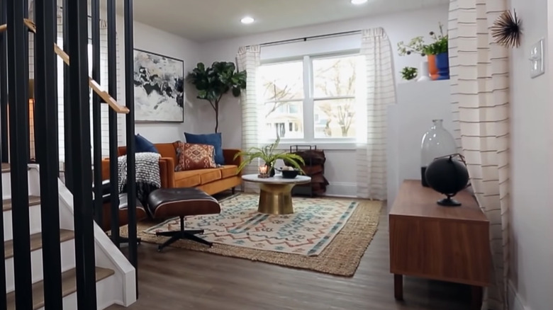 layered rugs with orange couch