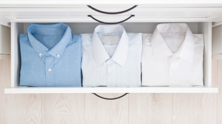 An open drawer with neatly folded shirts in it.
