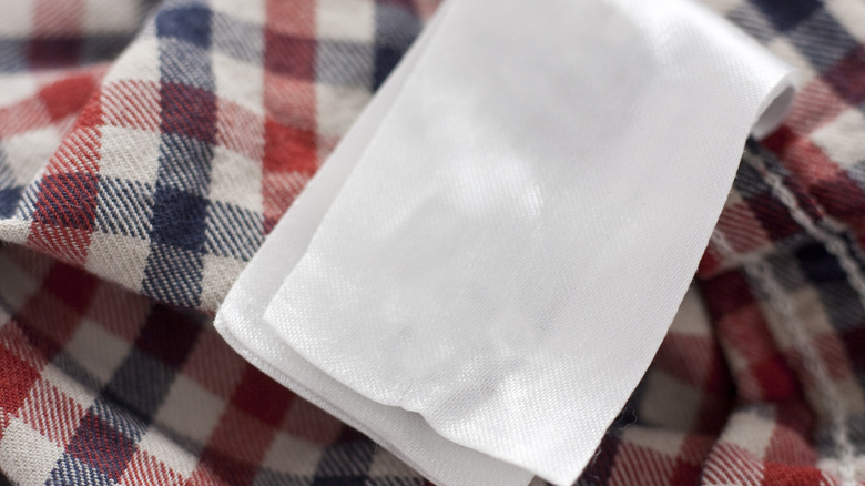 A dryer sheet on top of a gingham shirt