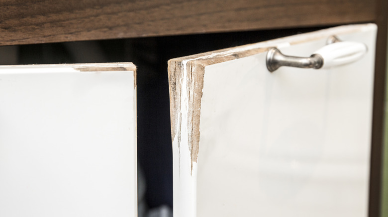 A white cabinet that is chipped and cracked