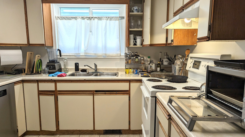 An old kitchen from the 1980s with white shelves and wood trim
