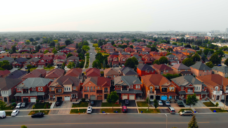 North American residential suburb with red homes and green trees and lawns