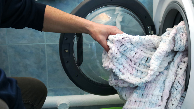 Person pulling thick winter blanket out of dryer