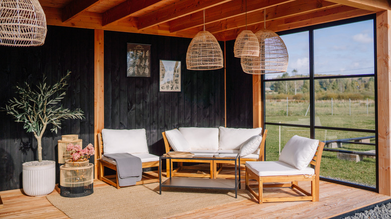A sheltered outdoor seating area with plants and comfortable furniture