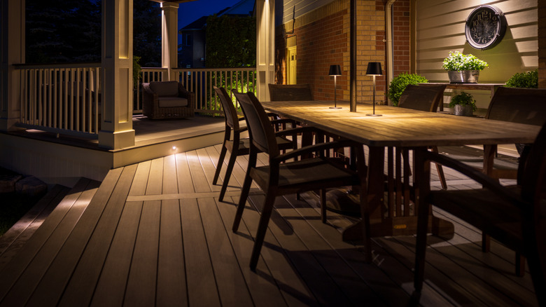 A beautiful wooden deck area at night, with furniture and lots of space to move