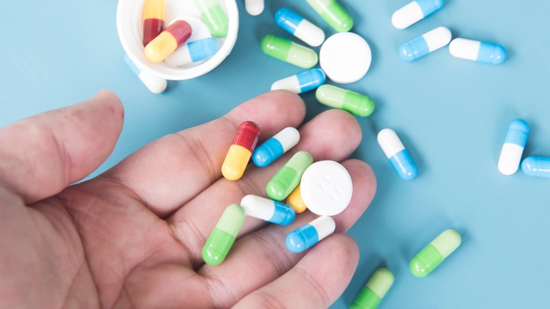 Person holding handful of medicine pills