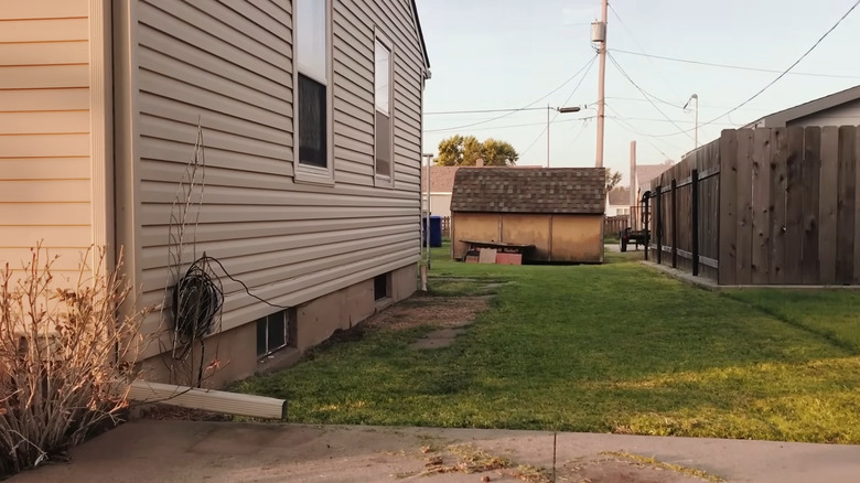 Home with sloped lawn leading towards the foundations