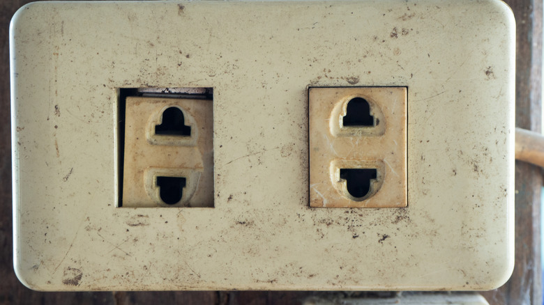 Old and dirty two-pronged outlet in a home