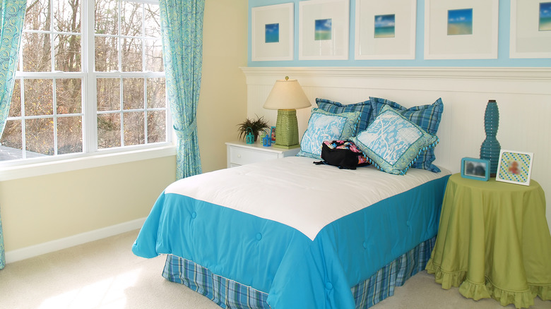 A well-laid bed with a blue bed skirt
