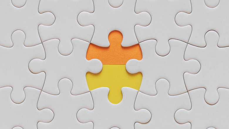 Close-up of a white puzzle with a missing piece