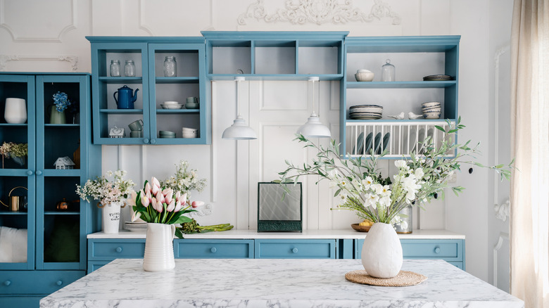 Two floral displays on a kitchen countertop