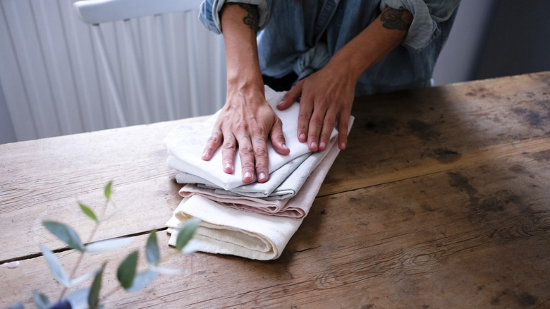 Closeup of person folding napkins on a table