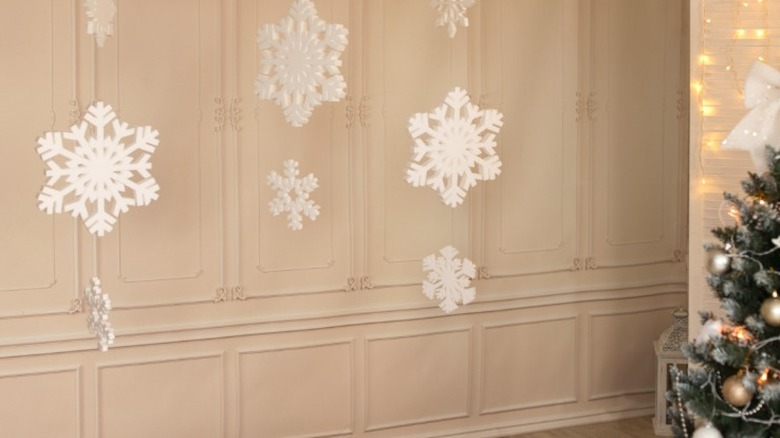 Paper snowflakes hanging along a blank wall