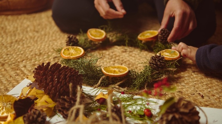 Someone crafting a simple wreath with natural elements