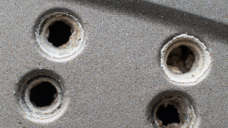A closeup of scale-encrusted steam holes on a clothes iron