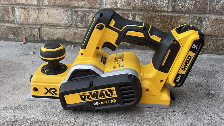 New DeWalt planer on hard rock surface with masonry backdrop