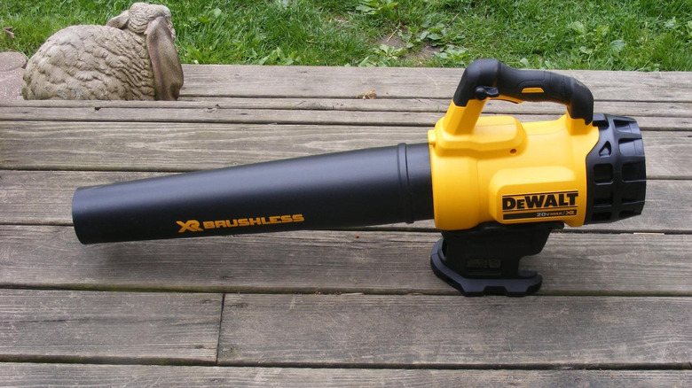 New DeWalt leaf blower on wood deck outside home beside rabbit statue