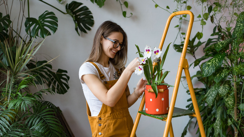 Woman holding an orchid indoors