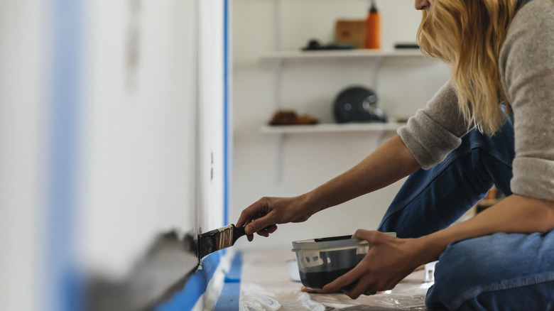 Closeup of woman painting a wall