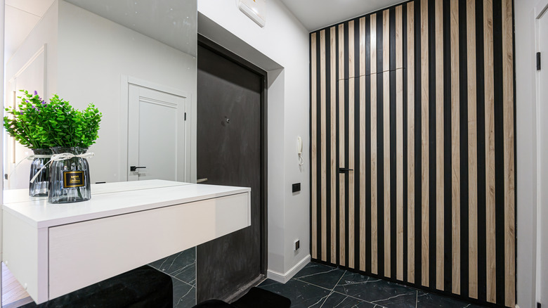 Entryway with striped wall camouflaging a door