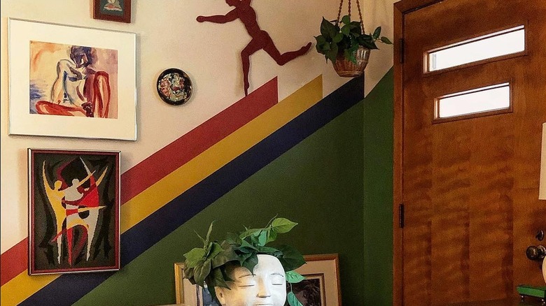 Multi-striped wall with art frames by a front door