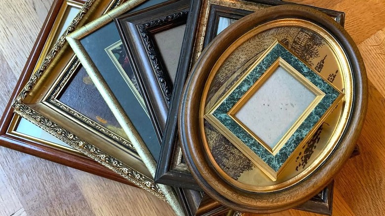 A stack of vintage picture frames over a wooden surface.