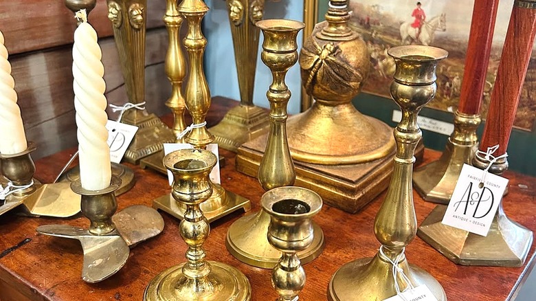 An assortment of antique brass and copper candle holders.