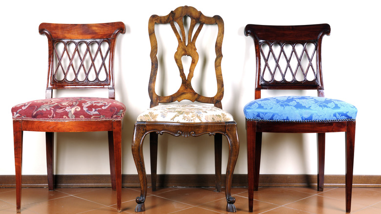 Three different vintage wooden chairs with colorful upholstery.