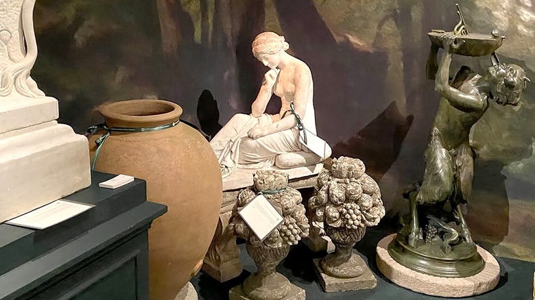 An exhibition of garden antiques including statues and a large vase.
