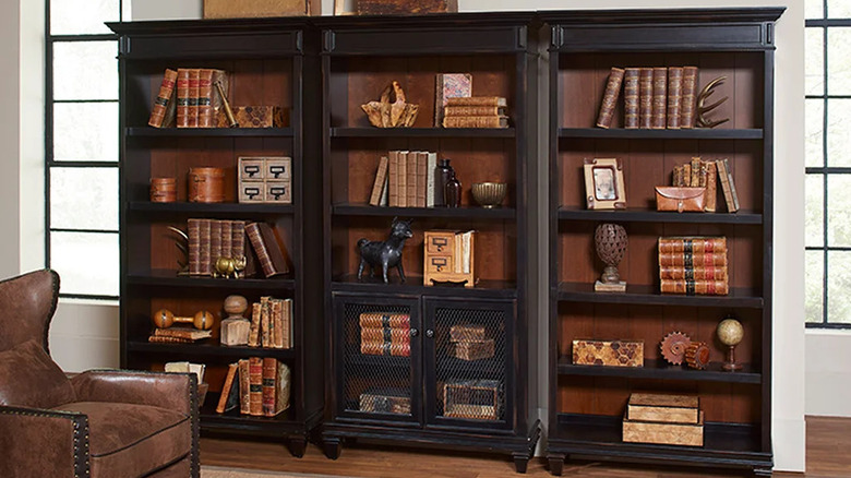 Dark wood bookcase wall styled with vintage decor