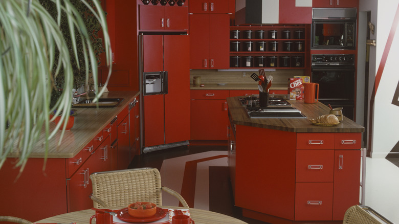 A colorful, red retro kitchen with an island and dine in set.