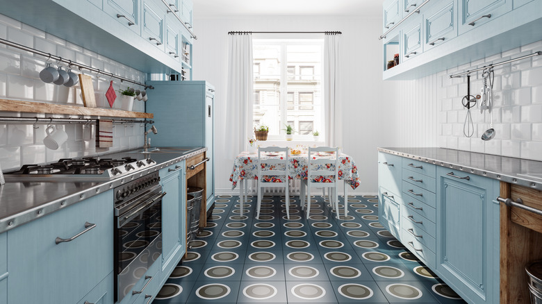 A kitchen with blue cabinets and bold psychedelic floors.