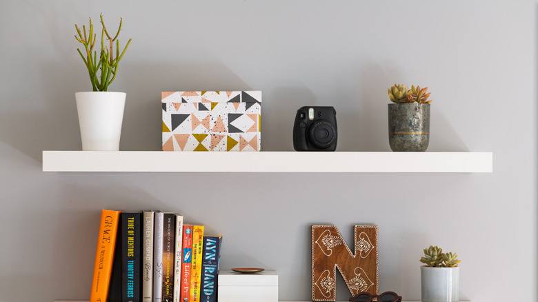 Floating shelves laden with plants, books, and other decorative items