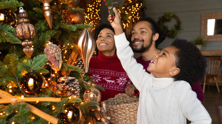 family decorating Christmas tree