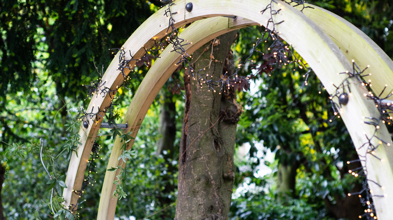 A wooden garden arch strung with fairy lights.