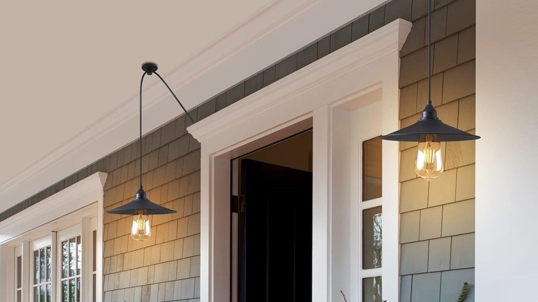 Two black hanging pendant lights suspended from the ceiling of a porch